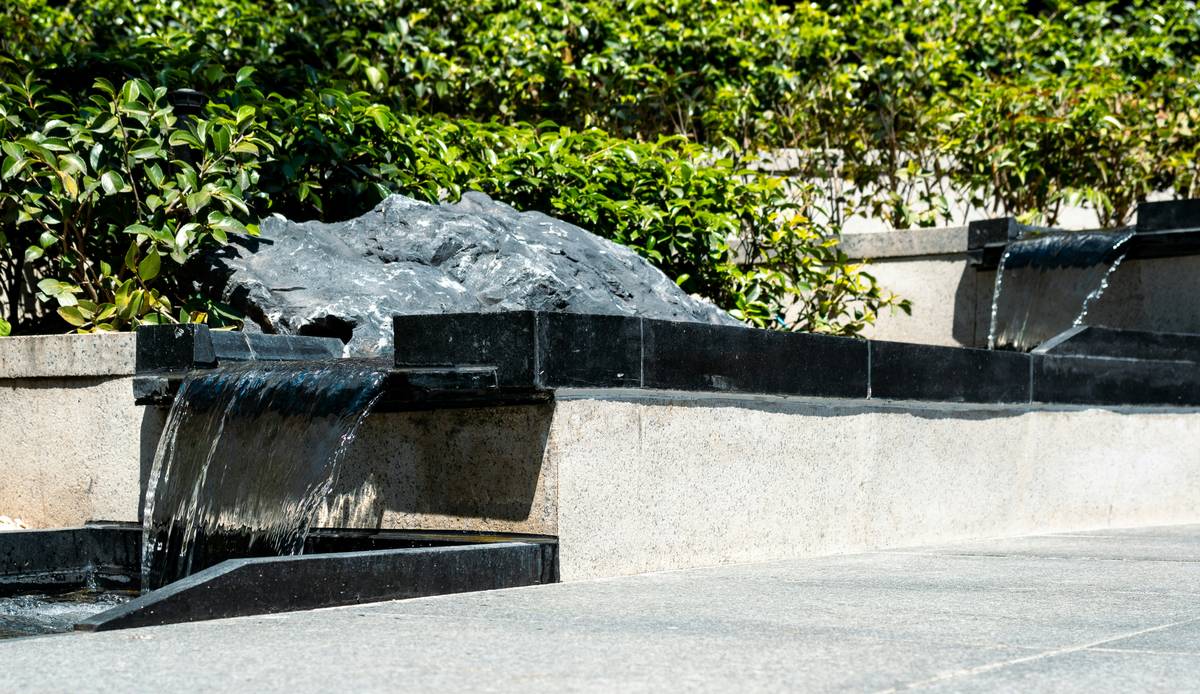DIY birdbath water feature with sloped stones and solar dripper attracting chickadees